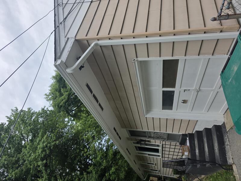 White vertical downspout installed on garage corner